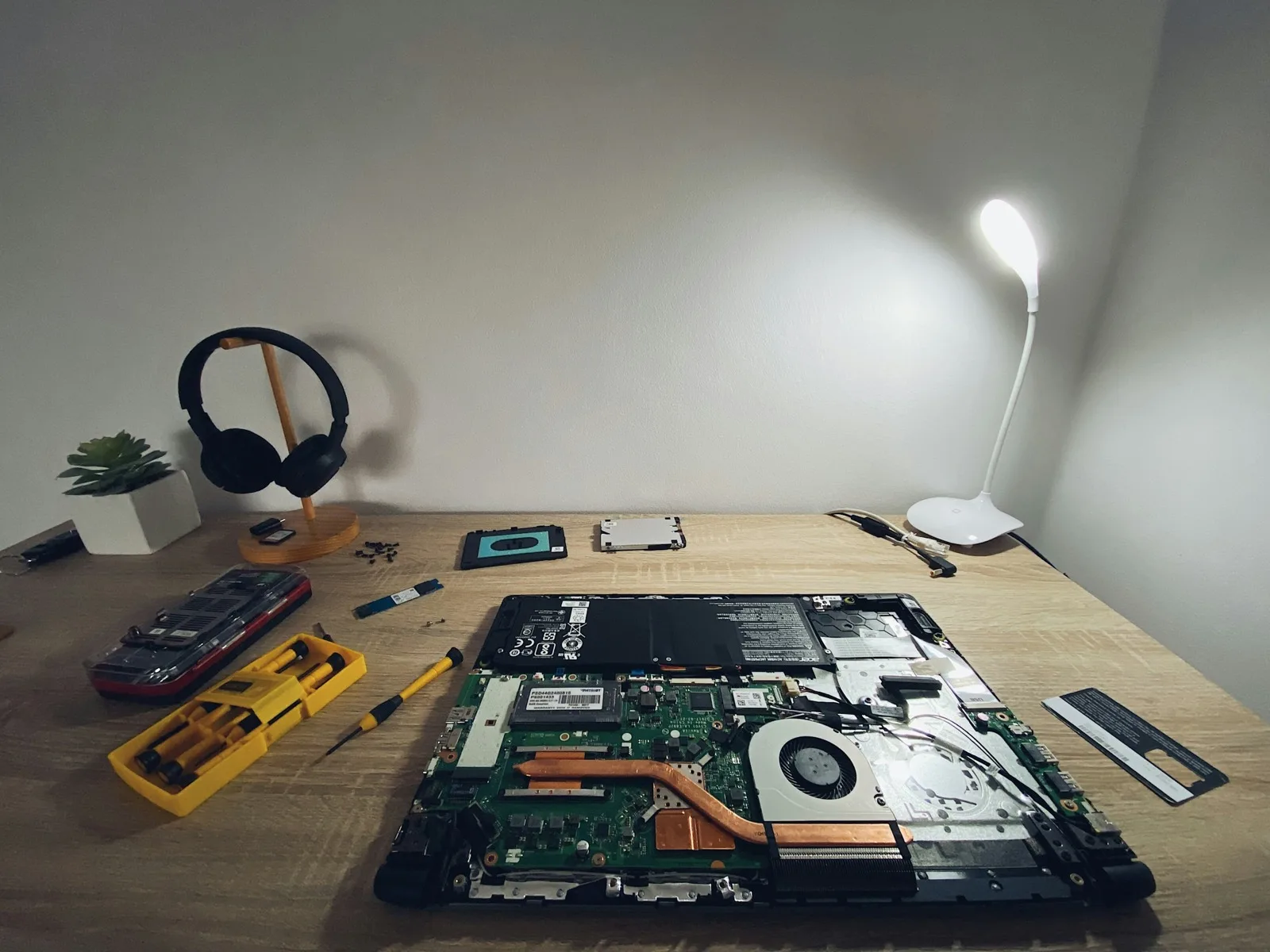A pair of headphones resting on a table beside a laptop